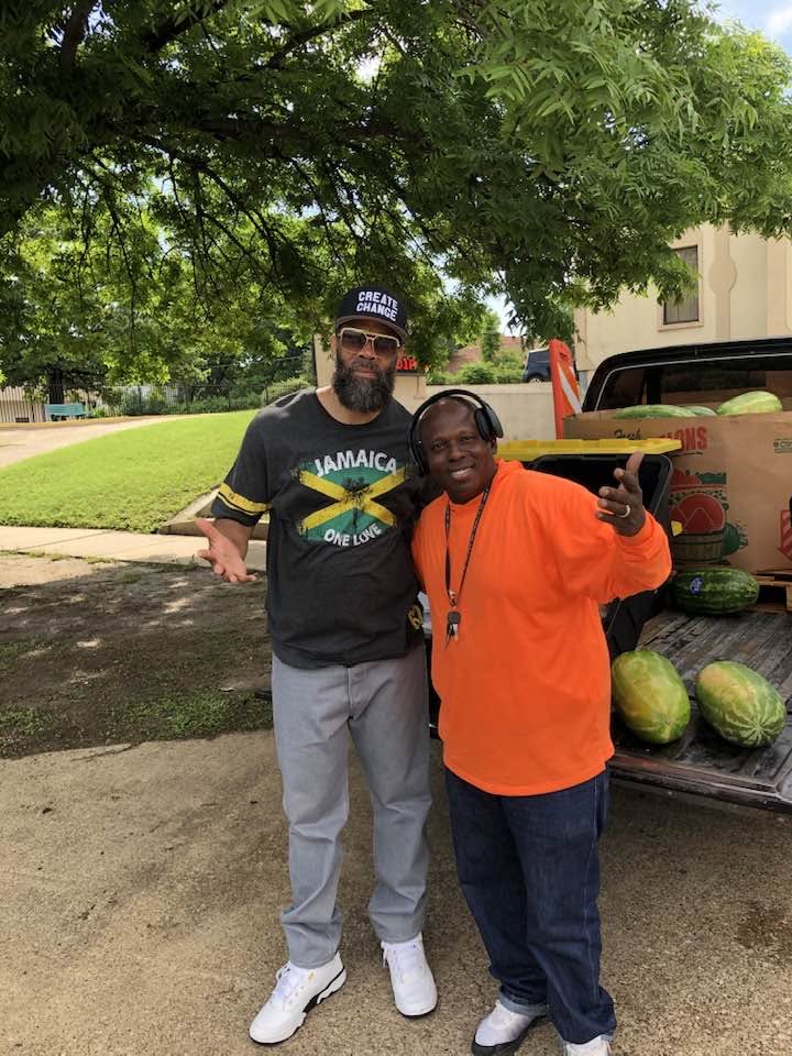 Two supporters posing by the truck loaded with fresh watermelons